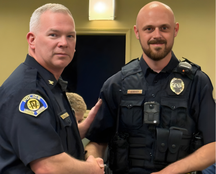 Chief Harrison and Officer Wommack - two men - shake hands